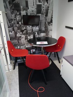 deux chaises rouges et une table noire dans une petite pièce