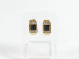 une paire de boucles d'oreilles noires et dorées ornées de diamants