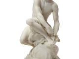 an image of a statue of a man sitting on a rock