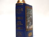 a blue book with gold trim sitting on a white surface