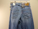 a pair of jeans hanging on a hanger on a wall