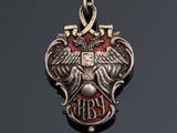 an image of a silver and red pendant with an eagle on it