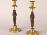 paire de bougeoirs anciens en laiton ornés de figures égyptiennes sur leurs socles
