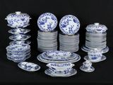 many blue and white plates and bowls on a black table