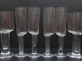 six verres à vin transparents alignés en rang sur une table