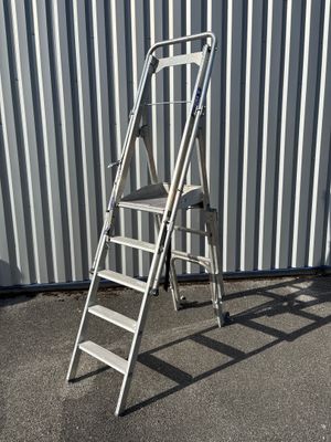 une échelle blanche appuyée contre un mur métallique