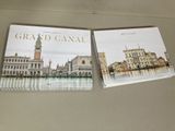 trois livres posés contre un mur, avec une horloge et un clocher en arrière-plan