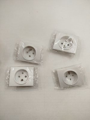 quatre prises électriques blanches sont recouvertes de plastique sur une surface blanche