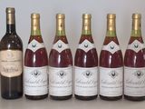 six bottles of wine are lined up on a table
