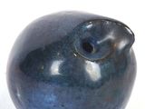 a blue vase with a bird on it on a white surface