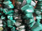 several pieces of green and black beads on a table