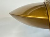 a close up of a gold object on a white surface