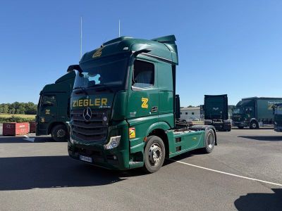 un camion vert garé sur un parking