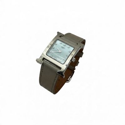 a silver watch with a brown leather band on a white background