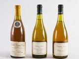 three bottles of wine sitting next to each other on a white surface