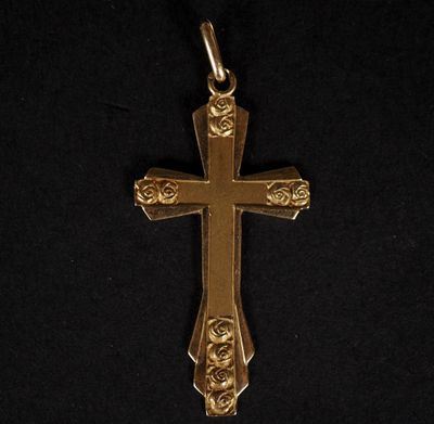 une croix dorée ornée de roses sur fond noir
