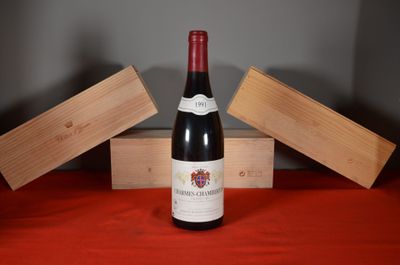 a bottle of wine sitting on a table next to a wooden box