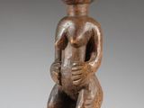 a wooden statue of a man holding a baby in his arms