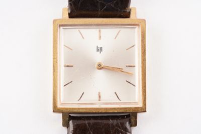 une image d'un gros plan d'une montre-bracelet sur une surface blanche