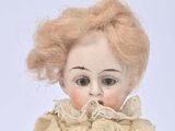 a doll that is sitting on a white surface