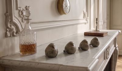 cinq petits oiseaux perchés sur une cheminée, à côté d'une horloge