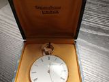 une horloge dans une boîte posée sur une table, avec une étiquette de prix
