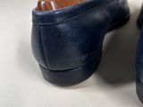 pair of men ' s blue leather shoes sitting on top of a white surface