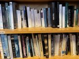 a book shelf with many books on it in a library