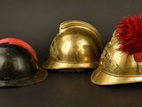 three helmets with red feathers on them on a black background
