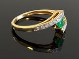 an image of a gold ring with a green stone and diamonds