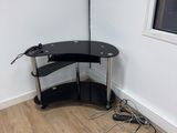 a corner desk with a lamp on top of it