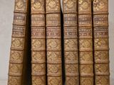 six vieux livres sont empilés sur une table