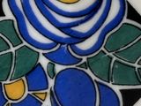a white plate with a blue rose design on it