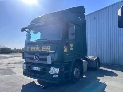 un camion vert garé devant un immeuble