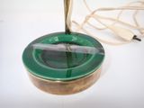 a green ashtray with a cigarette in it on a table