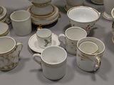 a lot of white and gold china on the table