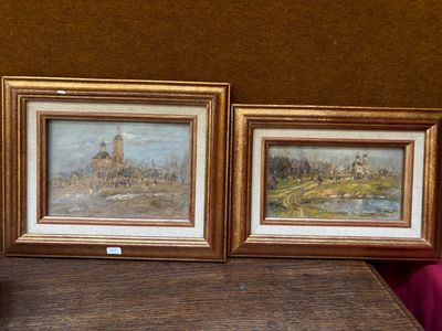 deux tableaux posés sur une table à côté d'un vase de fleurs