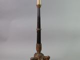 an antique brass and black lamp on a marble base