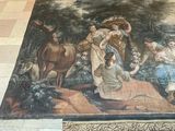 a painting on the floor of a room with a person standing in front of it