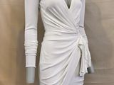 the mannequin is wearing a white dress with long sleeves