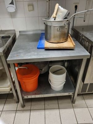 a kitchen with a stove, sink, and a pot on the counter