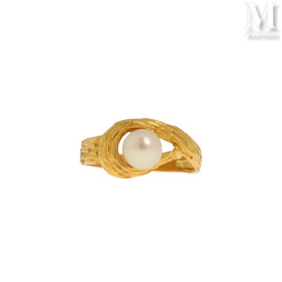 gros plan d'une bague en or contenant une perle