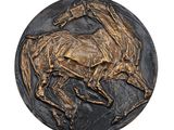une image représentant un médaillon en bronze en forme de cheval sur fond blanc