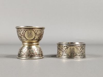 deux tasses en argent ornées de motifs, posées sur une table