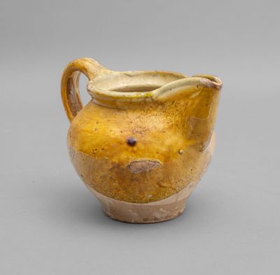 an image of a yellow vase on a gray background
