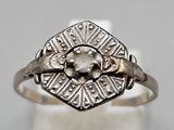 an antique silver ring with a diamond in the center