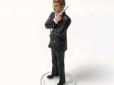 a figurine of a man in a suit holding a gun