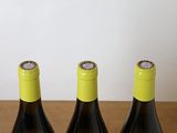 three bottles of wine sitting on top of a table next to each other