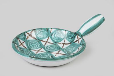 turquoise and white bowl with a spoon sitting on top of it