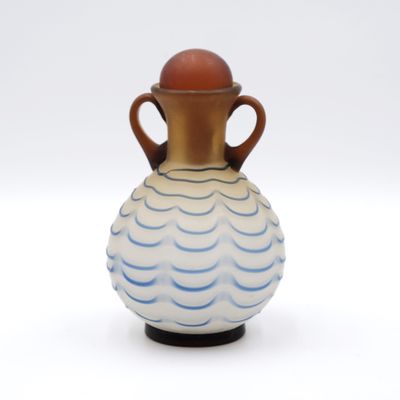 un vase bleu et blanc avec une anse marron sur un fond blanc
